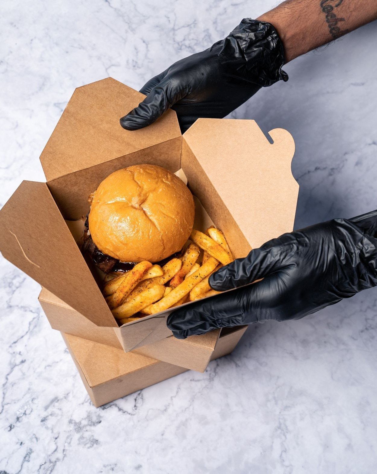 Caixa de delivery aberta com o lanche dentro