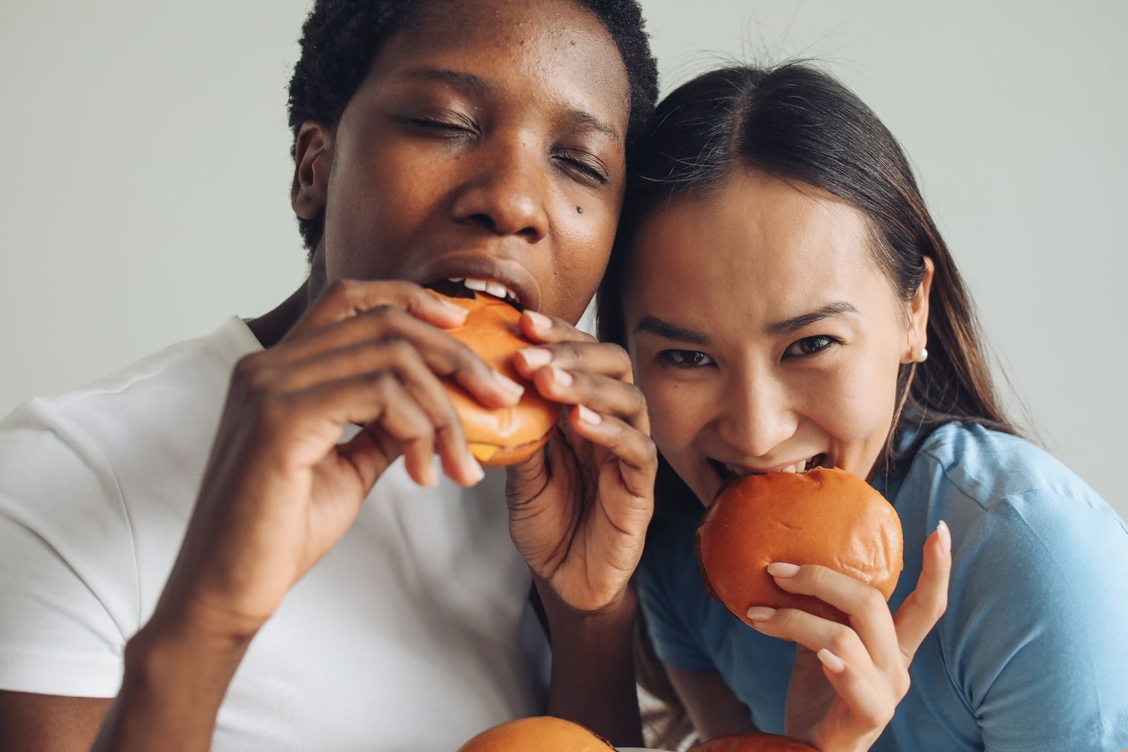 Duas amigas comendo hambúrguer